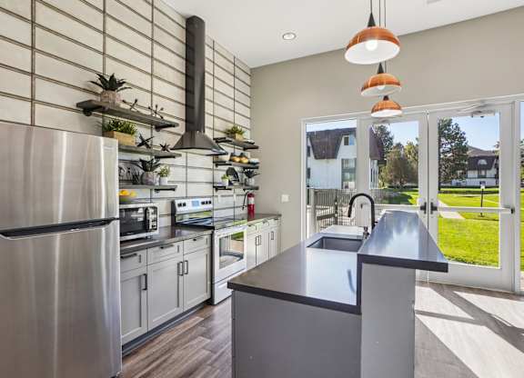 Resident kitchen lounge at Willowstone Apartments in Denver, featuring stainless-steel appliances and comfortable community seating