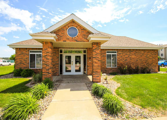 the front of a brick house with a walkway leading to the front door