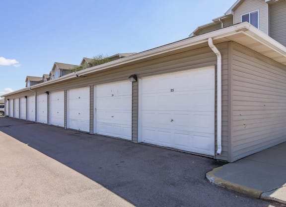 a row of white garage doors on a house