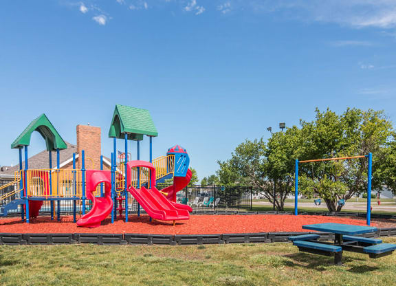 a playground with a picnic table and picnic table in front of it
