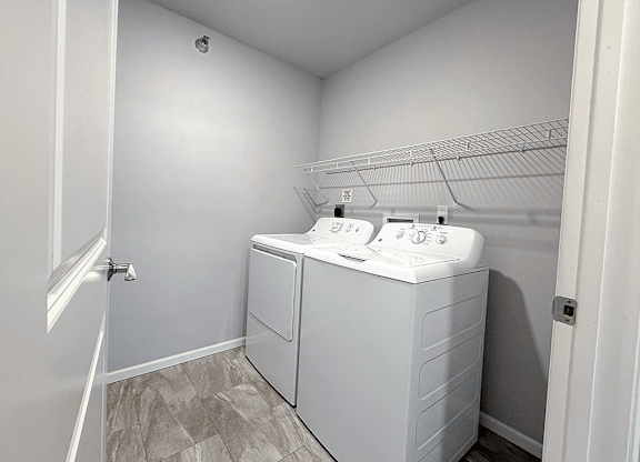 A white bathroom with a double sink and a white cabinet.