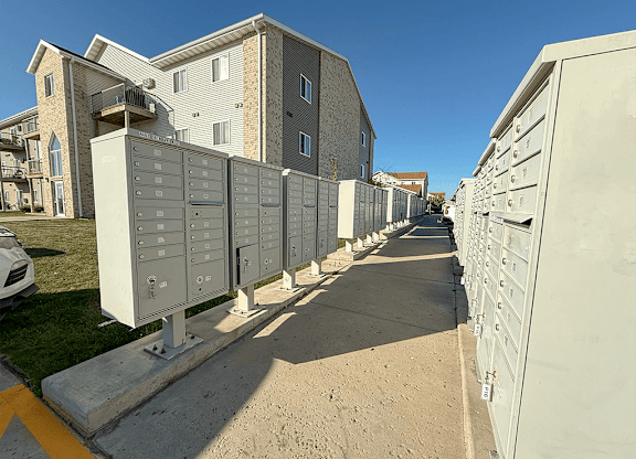 A row of mailboxes are lined up on a sidewalk.