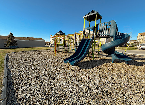 A playground with a blue slide and a yellow structure.