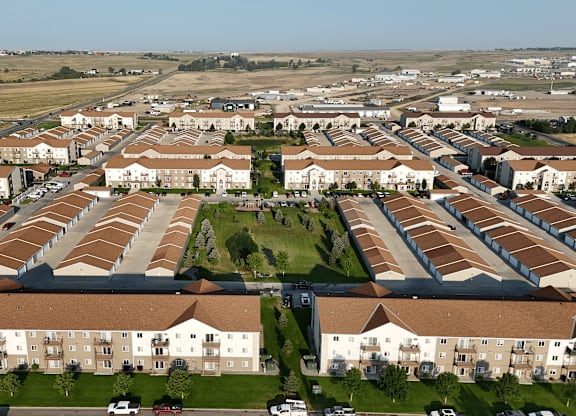 A large housing complex with a green lawn in the middle.