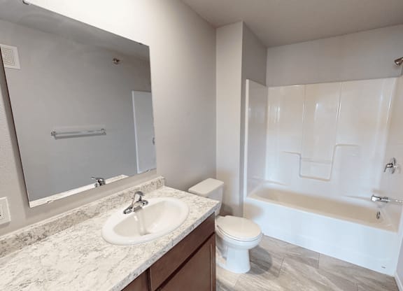 A bathroom with a sink, toilet, and bathtub.