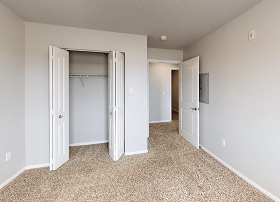 A room with a carpeted floor and a white door.
