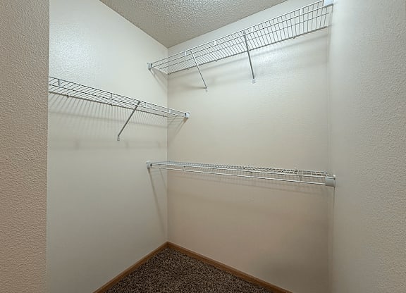 A white wall with a metal shelf on it.