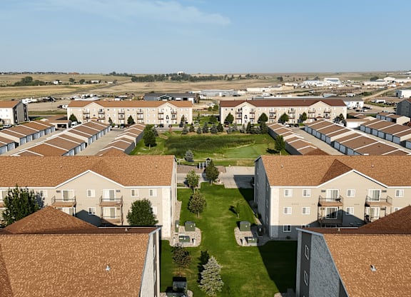 A large housing complex with a green lawn in the middle.