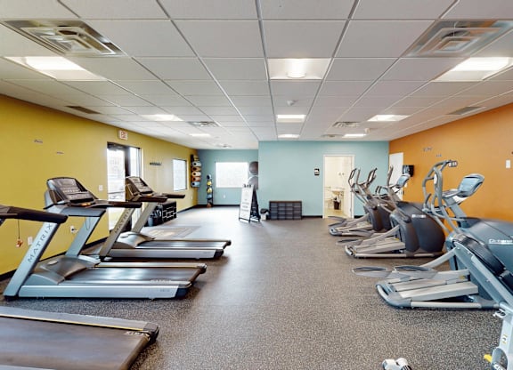 A gym with treadmills and elliptical machines.