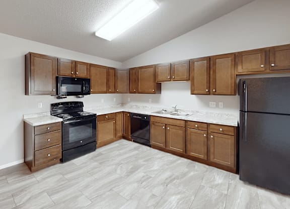 A kitchen with wooden cabinets and black appliances.