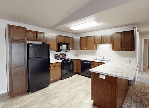 A kitchen with black appliances and wooden cabinets.