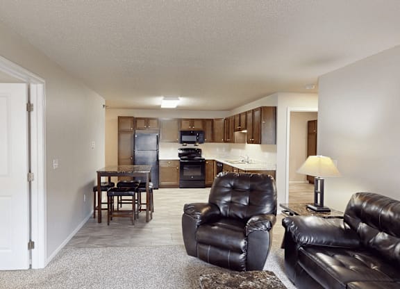 A living room with a black leather couch and chair.