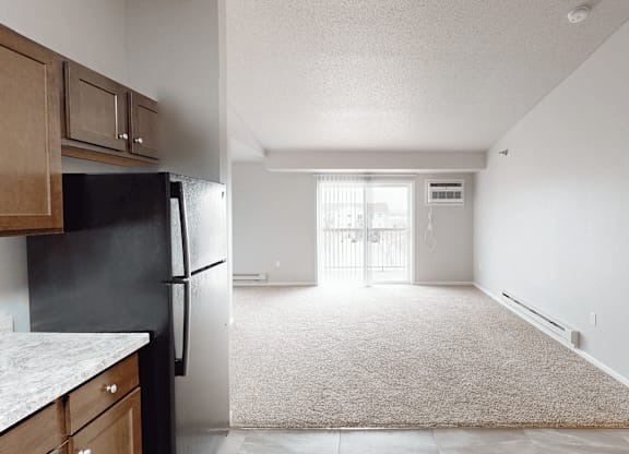 A black refrigerator sits in a kitchen next to a counter.