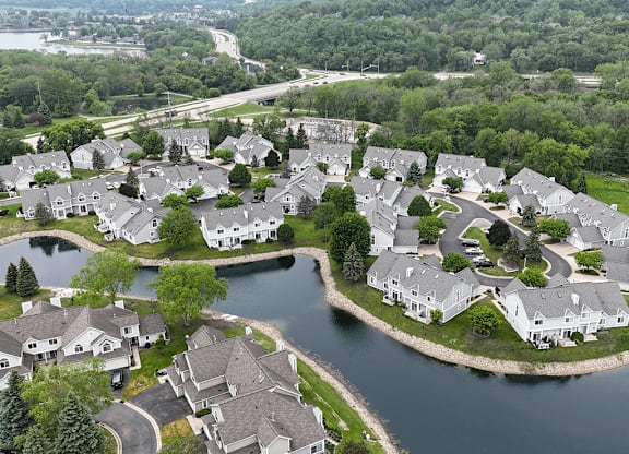 A bird's eye view of a residential area with houses surrounding a lake.