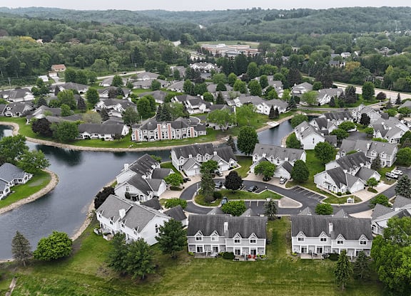 A bird's eye view of a residential neighborhood with houses and a lake.