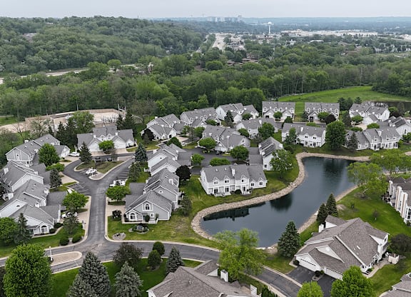 A bird's eye view of a residential neighborhood with houses and a lake.
