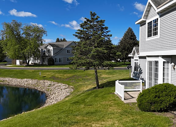 A house with a white fence and a tree in front of it.