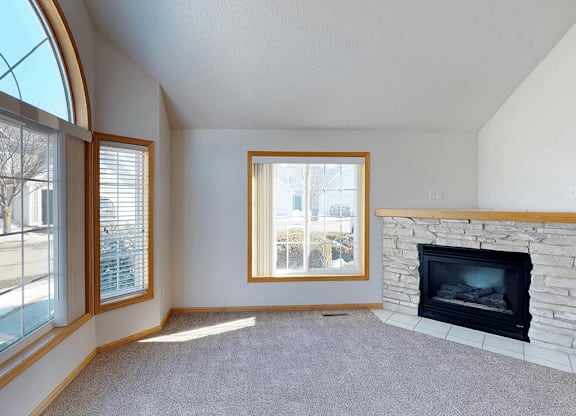 A living room with a fireplace and a large window.