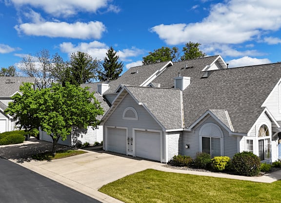 A house with a grey roof and a white garage door.