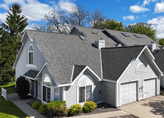 A large, two-story house with a grey roof and white walls.
