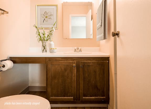 A bathroom with a wooden cabinet and a white sink