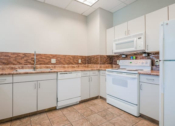 a kitchen with white appliances and white cabinets