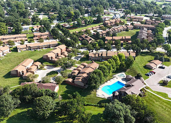 A bird's eye view of a residential area with houses and a swimming pool.