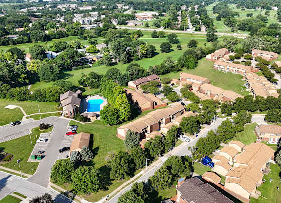 A bird's eye view of a residential area with houses and a swimming pool.
