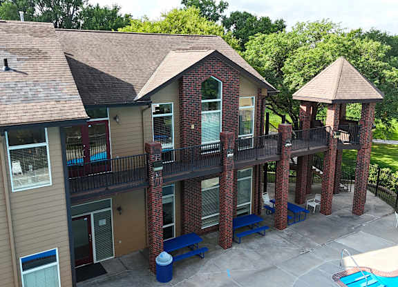 A small building with a balcony and a pool in front.