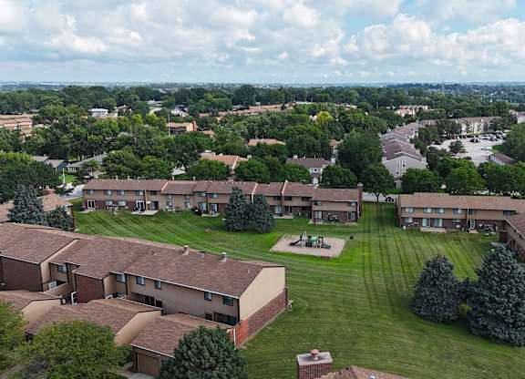 A large apartment complex with a green lawn in the foreground.