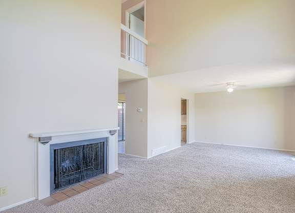 A living room with a fireplace and a carpet.
