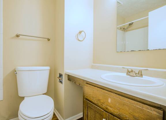 A white toilet sits next to a white sink in a bathroom.