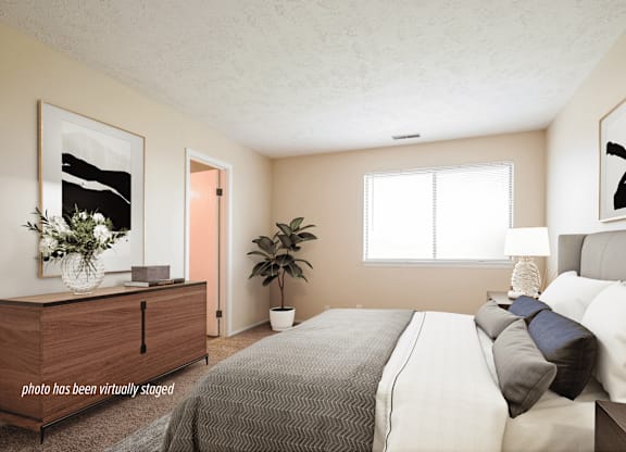 A bedroom with a bed, dresser, and window.