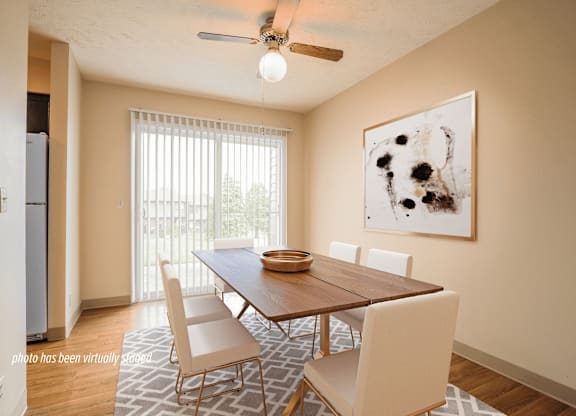 A dining room with a wooden table and chairs.