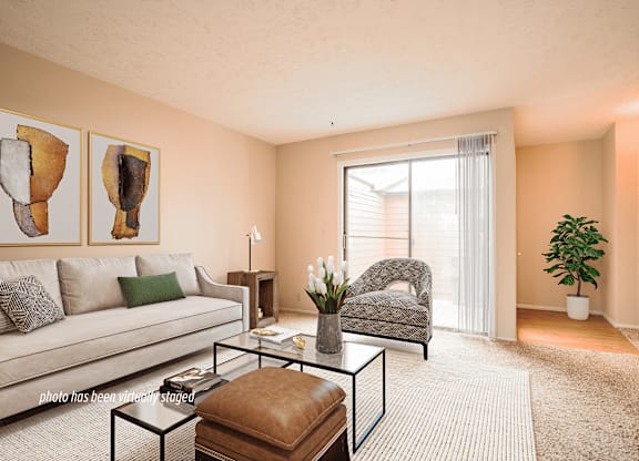 A living room with a couch, chair, and two paintings on the wall.