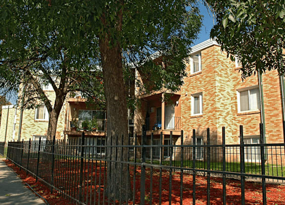 an apartment complex with a fence in front of it