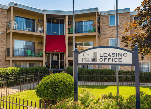 a leasing office sign in front of an apartment building