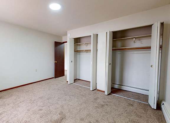 A room with a carpeted floor and a white ceiling with a light fixture.
