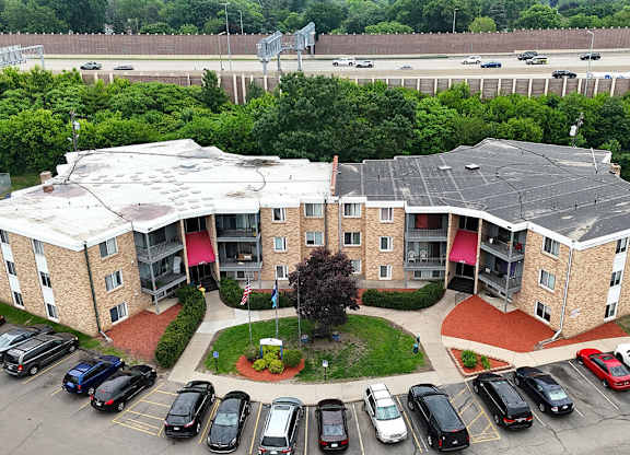 A parking lot in front of a building with a red roof.