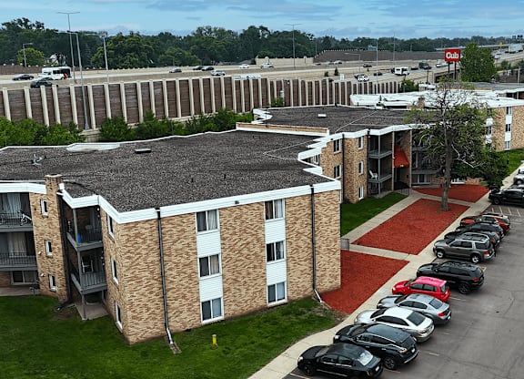 A parking lot with cars and a building in the background.