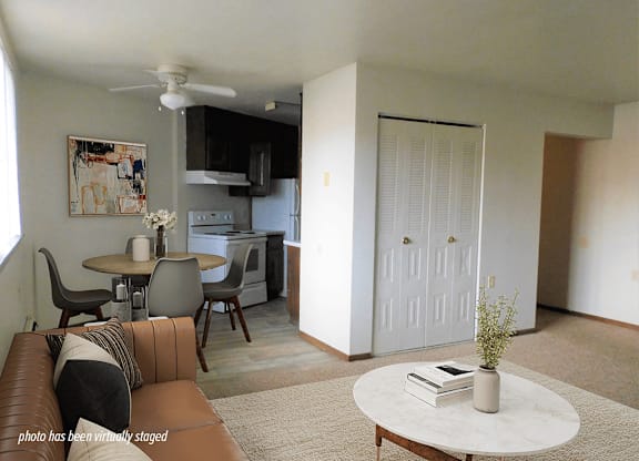 A living room with a brown leather couch and a white coffee table.