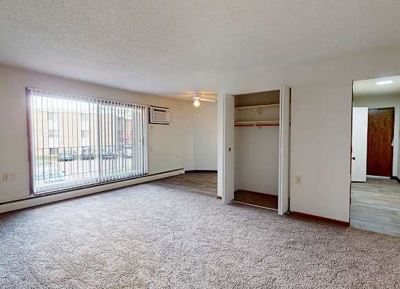 A room with a carpeted floor and a sliding glass door.