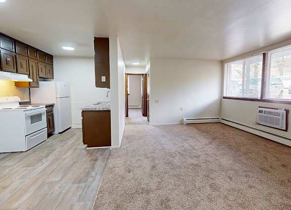 A kitchen with white appliances and wooden cabinets.