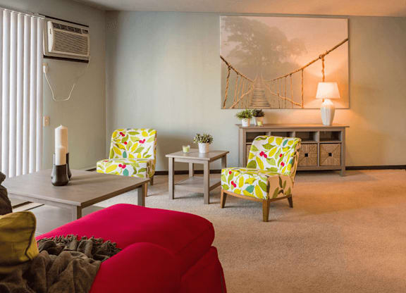 a living room with a red couch and yellow chairs