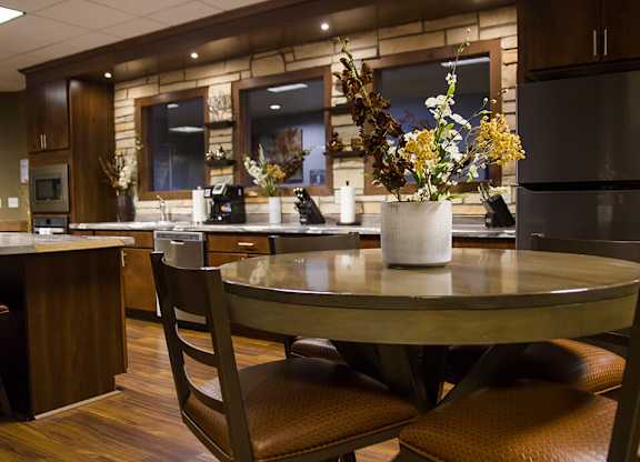 a kitchen with a round table with a vase of flowers on top of it