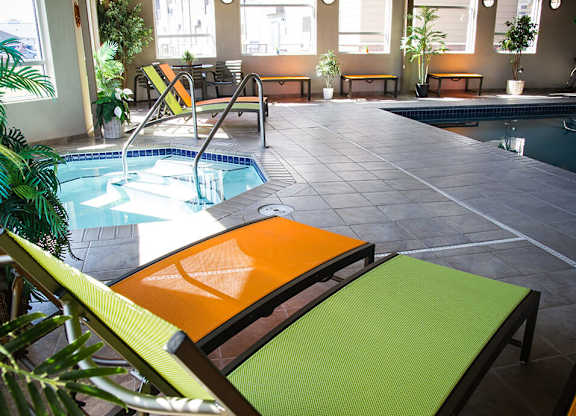 a pool area with lounge chairs and a plunge pool