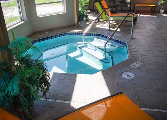 a plunge pool in a home with a tile floor and floor to ceiling windows