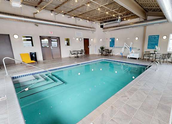 a large indoor swimming pool with chairs and tables