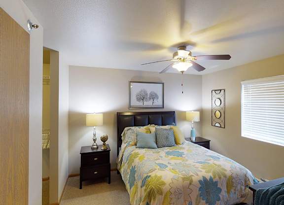 a bedroom with a bed and a ceiling fan