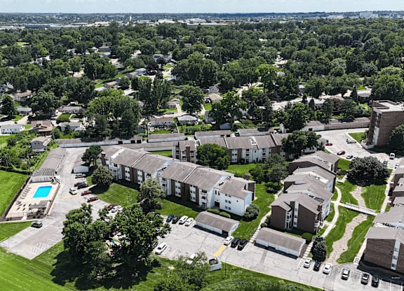 A bird's eye view of a residential area with houses and a swimming pool.